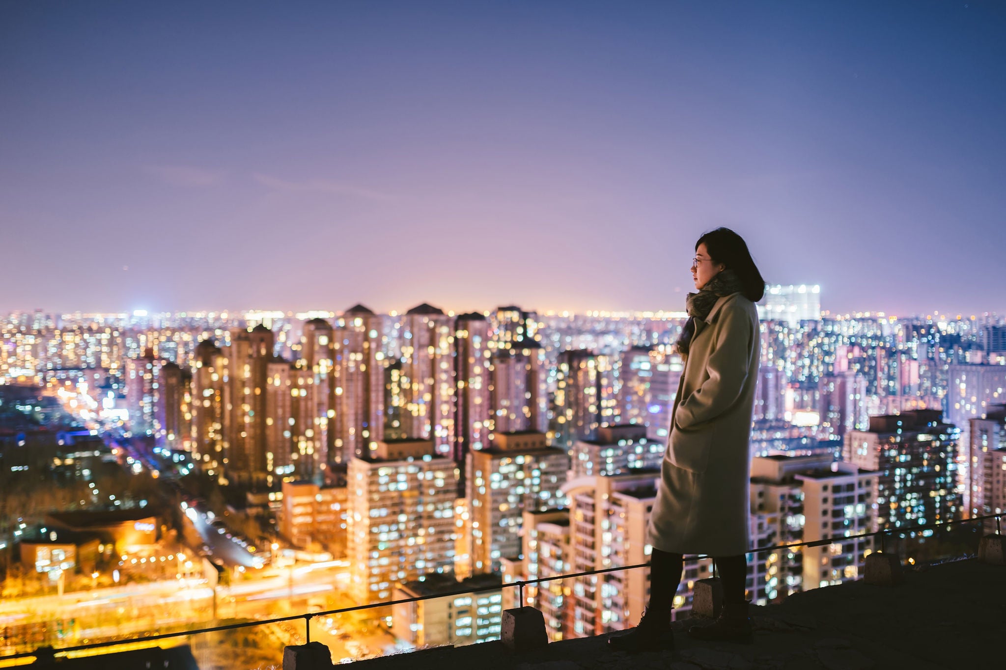 ey-woman-overlooking-city-at-night